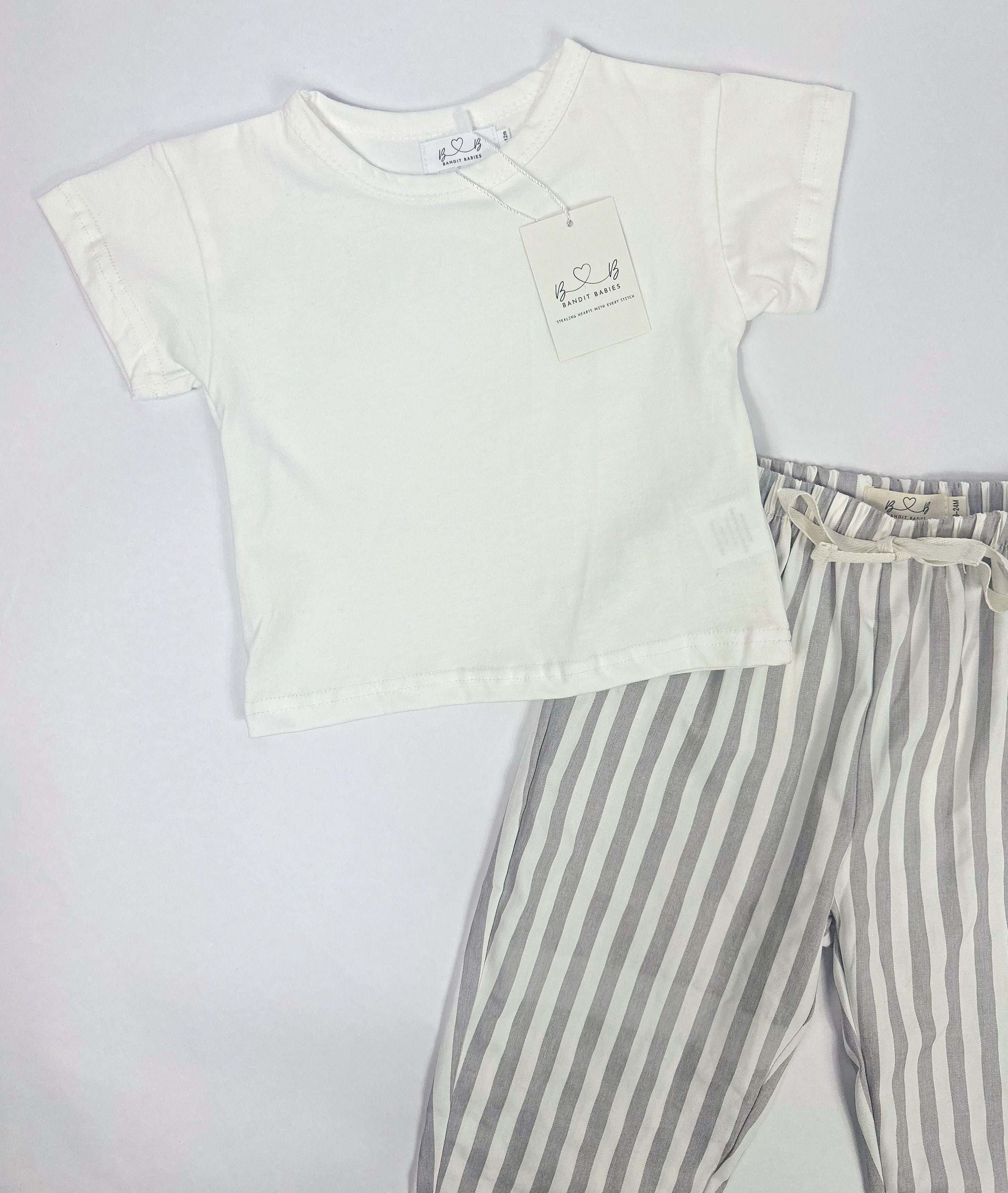 A toddler white t-shirt and grey and white striped pants on a white background.