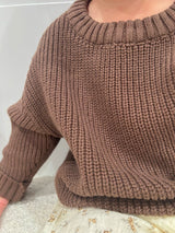 Close-up of a brown knitted sweater on a neutral background