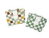 Two folded checkered footies, one multicolored and one green and white, on a white background.