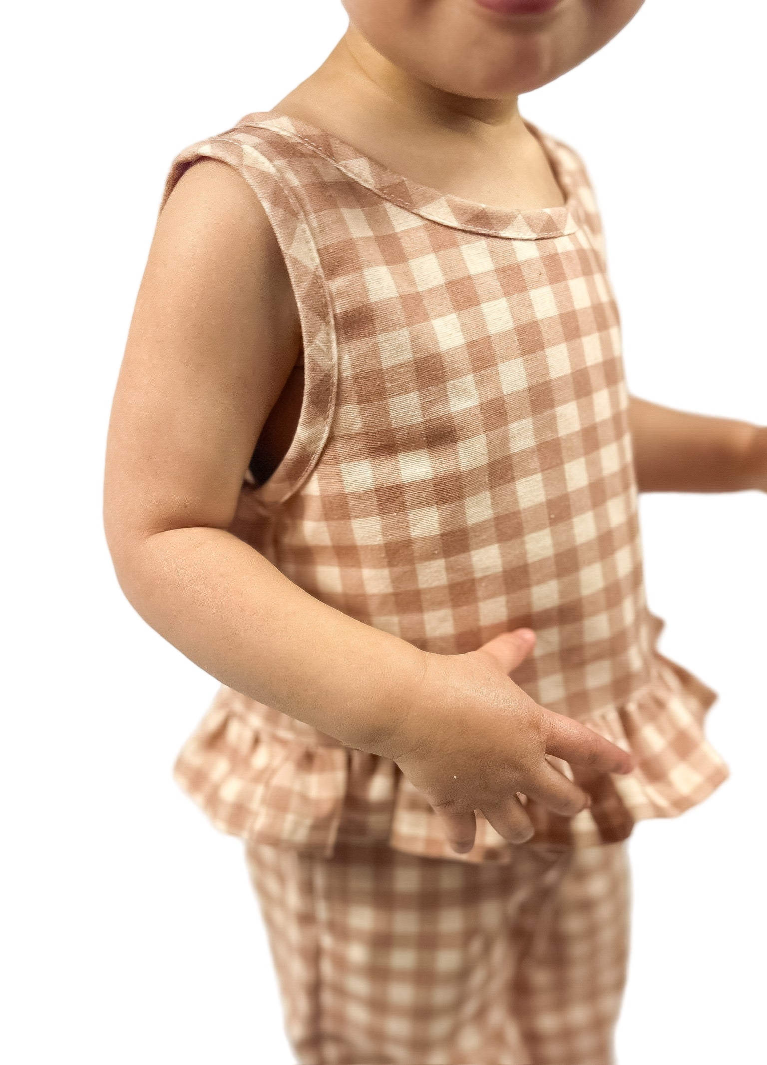 A child wearing a beige and brown gingham tank top and matching pants set.