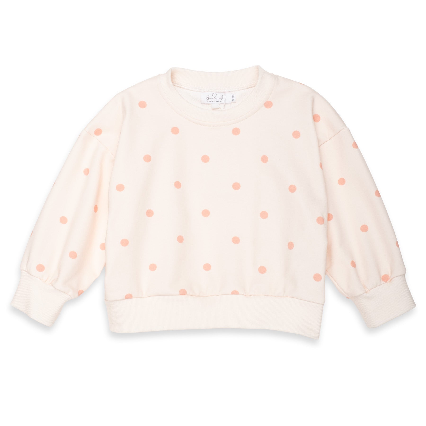 A pale pink long-sleeve crewneck sweatshirt with a pattern of small peach-pink polka dots, displayed flat against a white background.