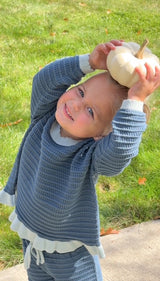 a child holding a white pumpkin on her head