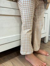 a child's gingham pattern leggings cropped to show legs and feet.