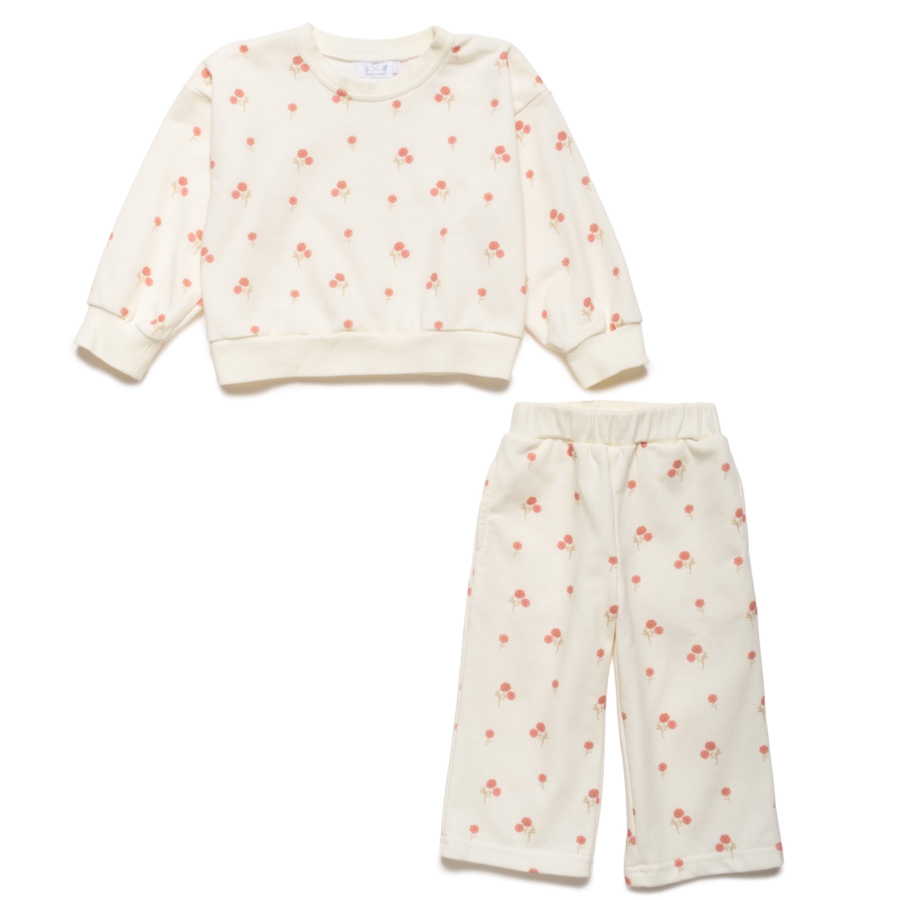 Children's outfit with a cream-colored sweatshirt and pants featuring small red floral patterns on a white background.