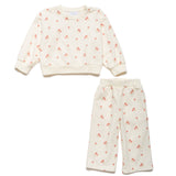 Children's outfit with a cream-colored sweatshirt and pants featuring small red floral patterns on a white background.